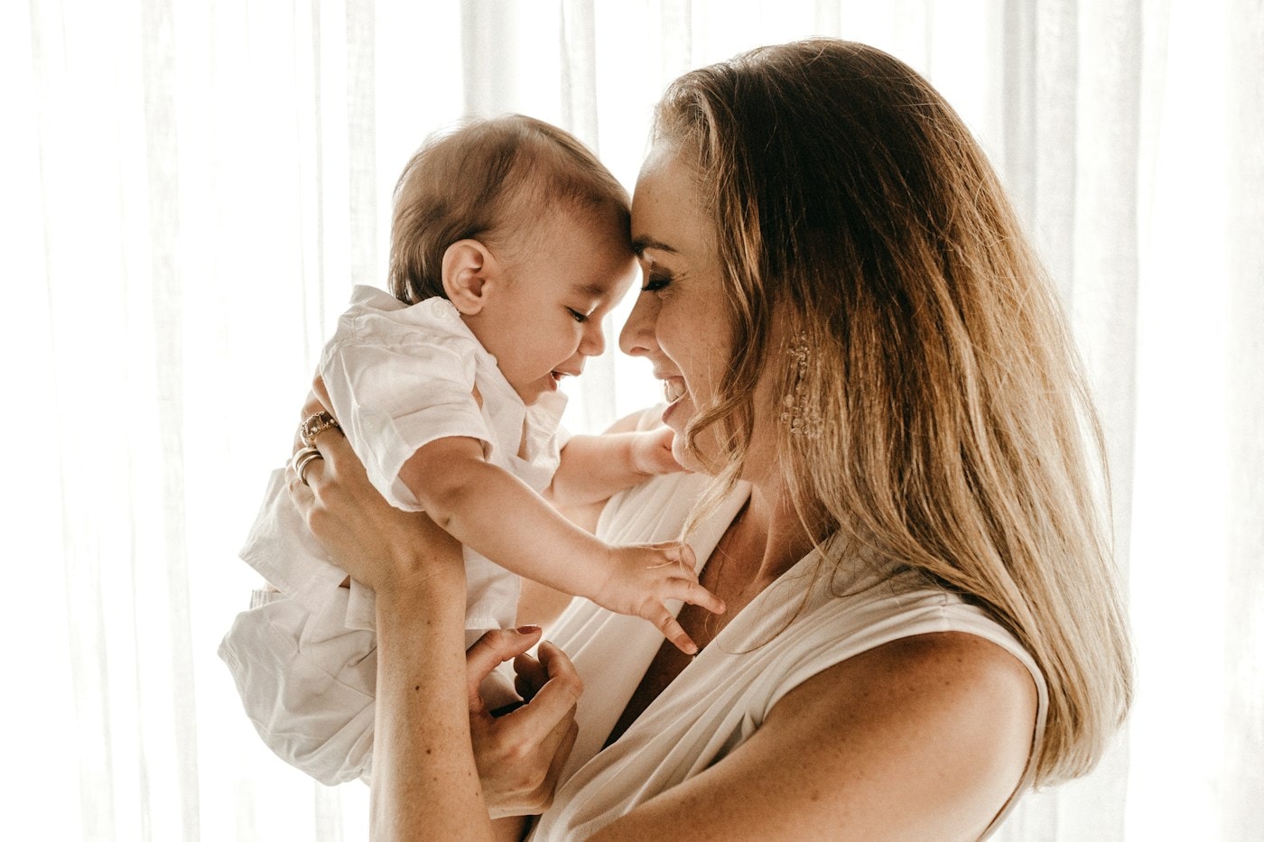 Mãe e bebê próximos, em um gesto cotidiano de carinho